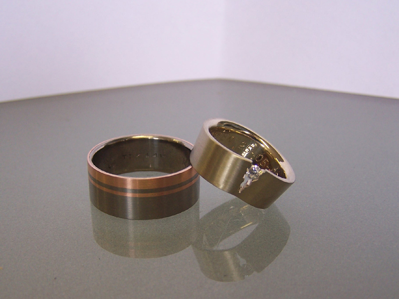 titanium ring ingelegd met rosgouden banden en witgouden ring met diamant
